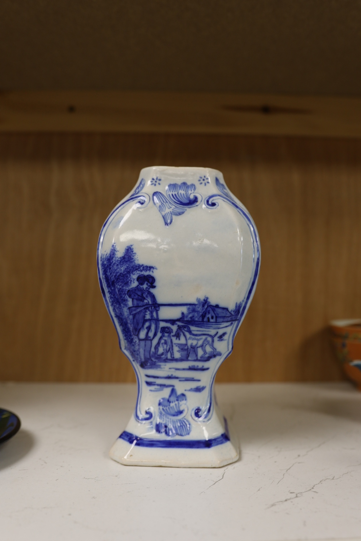 A 19th century Delft blue and white vase and a Watcombe Torquay pottery chamberstick, 19.5cm. Condition - both fair